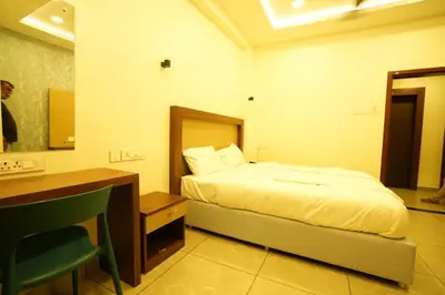 a bedroom with a bed and a desk and a sink at SREENARAYANA TOURIST HOME in Guruvāyūr