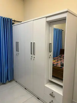 a white cabinet with a mirror in a bedroom at Chaithanya Residency Near to NIT Kozhikode in Kunnamangalam