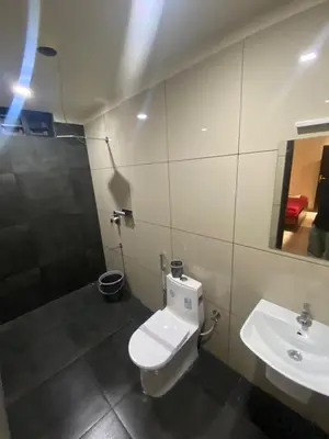 a bathroom with a toilet and a sink at Redbell Suites Kizhisseri in Kondotti