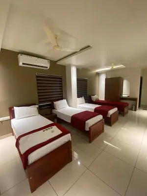 a hotel room with two beds in a room at Redbell Suites Kizhisseri in Kondotti