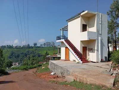 a white house on a hill with a staircase at Sandy Castle Villa 3 Bhk Homestay in Ooty