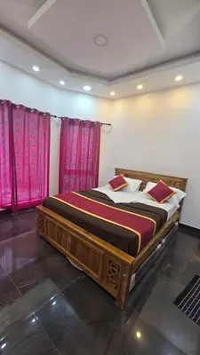 a large bed in a room with pink curtains at Sandy Castle Villa 3 Bhk Homestay in Ooty