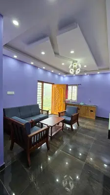 a living room with a couch and a table at Sandy Castle Villa 3 Bhk Homestay in Ooty