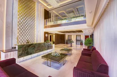a lobby with couches and tables in a building at Regenta Central Javaji Mysore in Mysore
