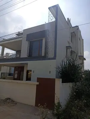 a large white house with a fence in front of it at Tranquil Haven Villa Homestay in Mysore