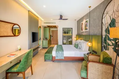 a hotel room with a bed and a desk at Flora Misty Falls Athirappilly in Athirappilly