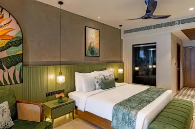 a hotel room with a bed and a couch at Flora Misty Falls Athirappilly in Athirappilly