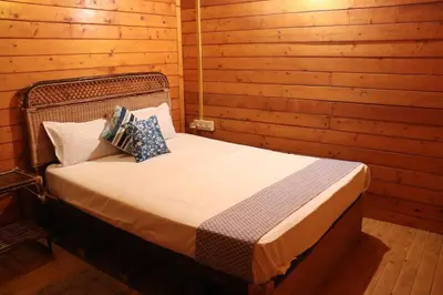a bedroom with a bed in a wooden cabin at Coorg Northbreeze Wooden Stay in Madikeri