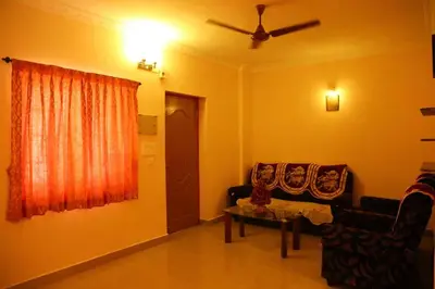 a living room with two chairs and a window at PRANOV RESIDENCY-Luxury in Coimbatore