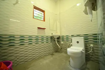 a bathroom with a toilet and a window at Coorg HomeStay Resort in Kushālnagar