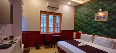 a bedroom with a bed and a green wall at Empire Pool Villa in Meenangadi