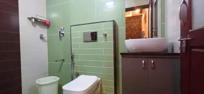 a bathroom with a sink and a toilet and a mirror at Empire Pool Villa in Meenangadi