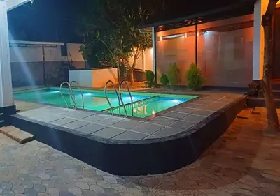 a swimming pool in a backyard at night at Empire Pool Villa in Meenangadi