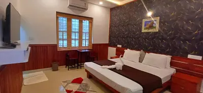 a bedroom with a bed and a television in it at Empire Pool Villa in Meenangadi