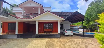 a house with a car parked in front of it at Empire Pool Villa in Meenangadi