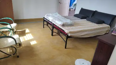 a room with two beds and a table in it at Karimbummel House- A room with spacious Balcony in Mysore