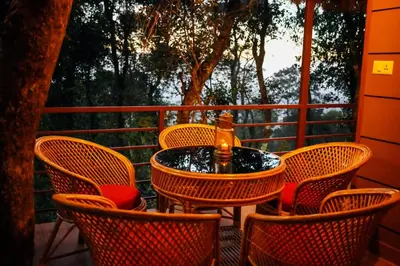 a table and chairs on a porch with a tree at Coffee Cradle Wayanad Luxuorios Private Tree House - Inside 2 Acre Coffee Plantation in Mananthavady