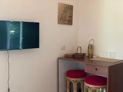 a room with two stools and a table with a television at Coffee Cradle Wayanad Luxuorios Private Tree House - Inside 2 Acre Coffee Plantation in Mananthavady