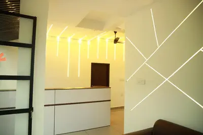 a kitchen with white walls and white cabinets at AROMA INN in Kalpetta