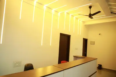 an office room with a ceiling fan and a desk at AROMA INN in Kalpetta