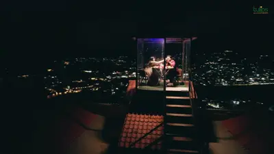 two people sitting on a lookout tower at night at Tulips Resorts - Elkhill in Ooty