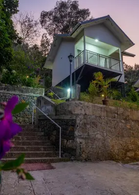 a house with a staircase leading up to it at Munnar Majestic Resort with Pool in Munnar