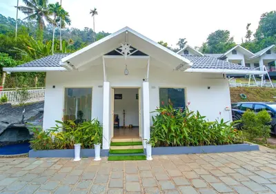a small white house with a front porch at Munnar Majestic Resort with Pool in Munnar