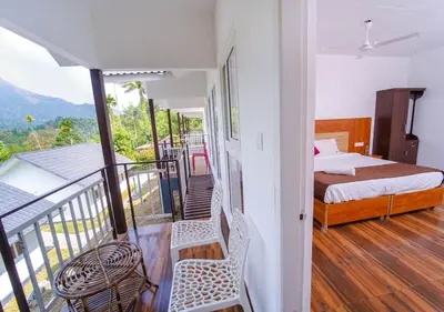 a bedroom with a bed and a balcony at Munnar Majestic Resort with Pool in Munnar