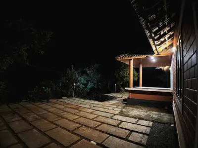a night view of a brick walkway next to a building at Mahout Resort Wayanad - An Experiential Jungle Stay with Waterfall in Kalpetta