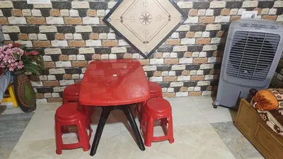 a couple of red chairs sitting next to a wall at Sahara Family Homestay in Mysore