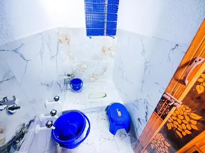 a bathroom with a blue toilet and a sink at Sahara Family Homestay in Mysore