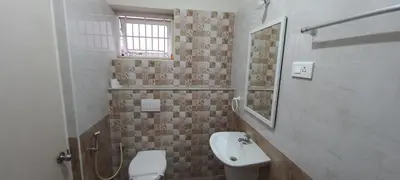 a bathroom with a sink and a toilet and a mirror at Shantham Service Apartments, Indumanagar, Coimbatore in Coimbatore