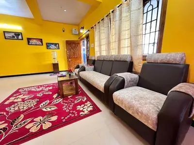 a waiting room with chairs and a red rug at Golden View Cottage Ooty in Ooty