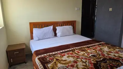 a bedroom with a large bed with a wooden headboard at Golden View Cottage Ooty in Ooty