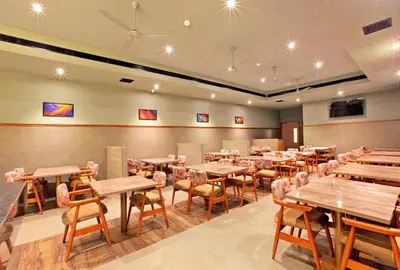 a dining room with wooden tables and chairs at PARK RESIDENCY ARCADIA in Alwaye