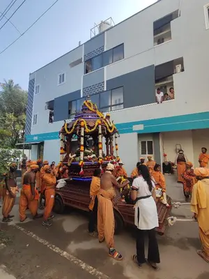 a group of men in orange robes standing around a truck at Sri Aksha Residency in Alāndurai