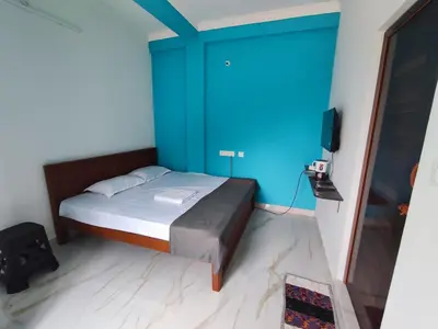 a bedroom with a bed with a blue wall at Sri Aksha Residency in Alāndurai