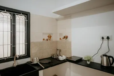 a kitchen with a black counter and a window at RD VILLA in Perundurai