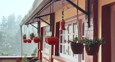 a row of potted plants hanging from a building at Kanjira house in Ooty