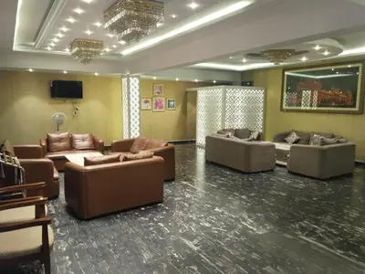 a living room with couches and a flat screen tv at Grand Milestone in Mysore