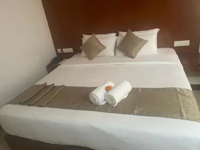 a large white bed with two pillows on it at Nakshatra Emerald in Guruvāyūr
