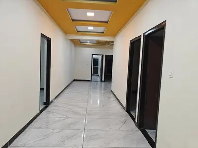 a corridor of an office building with doors and a tile floor at Comfort Cove Apartments in Mysore