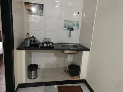 a small kitchen with a sink and a counter at Comfort Cove Apartments in Mysore