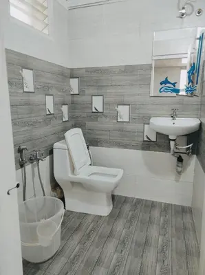 a bathroom with a toilet and a sink at COTTAGE GARDEN DEEPIKAS in Parambikolam
