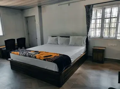 a bedroom with a bed in a room with windows at COTTAGE GARDEN DEEPIKAS in Parambikolam