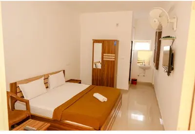 a small bedroom with a bed and a sink at sevens residency in Sultan Bathery