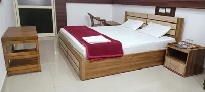 a bedroom with a large bed and a table at sevens residency in Sultan Bathery