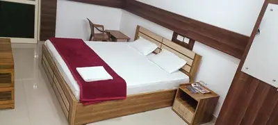 a bedroom with a bed with a red blanket on it at sevens residency in Sultan Bathery