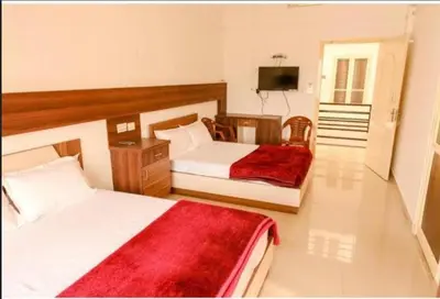 a hotel room with two beds and a television at sevens residency in Sultan Bathery