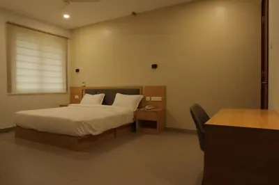 a bedroom with a bed and a desk with a telephone at Dreamotel Luxury Suites in Kanjikode